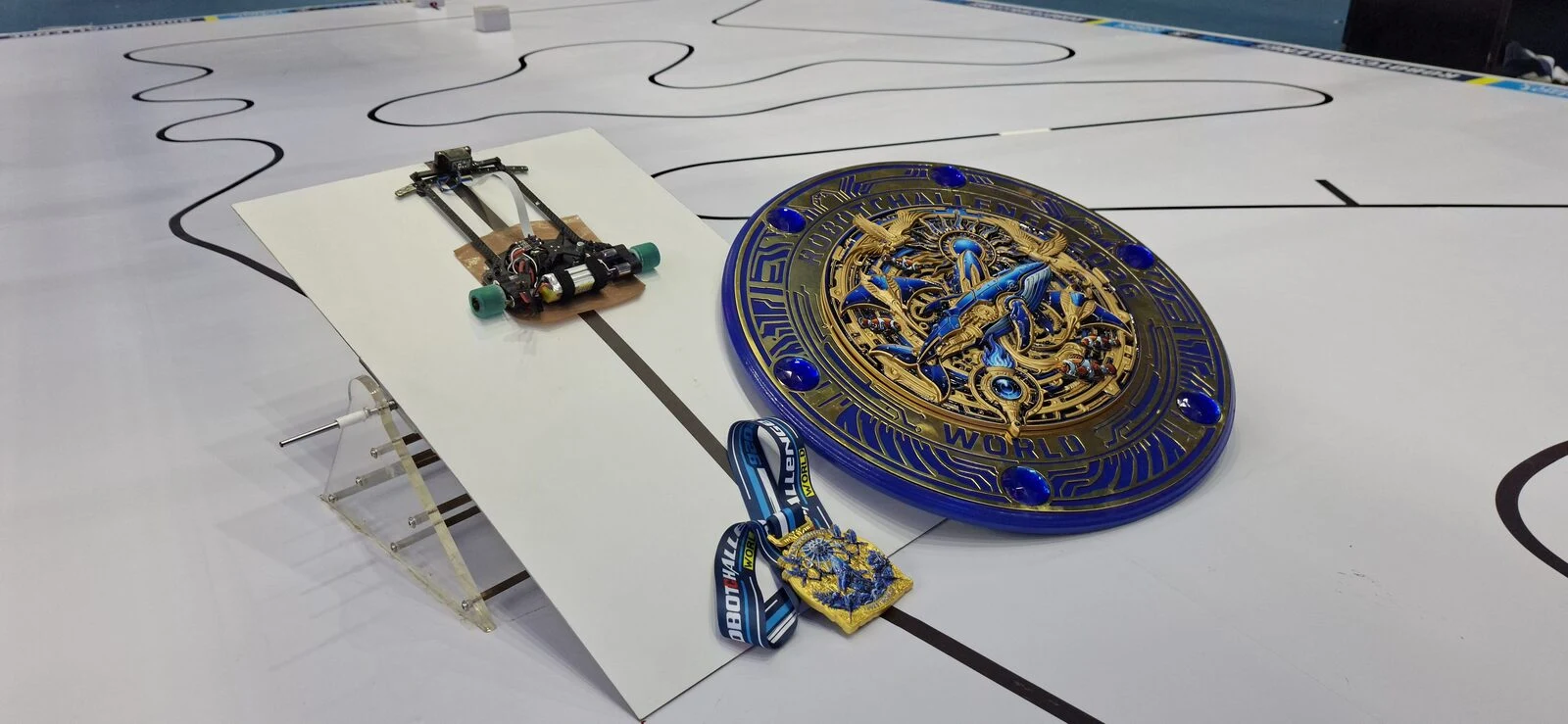 Line follower robot with the RobotChallenge China 2026 trophy and medal