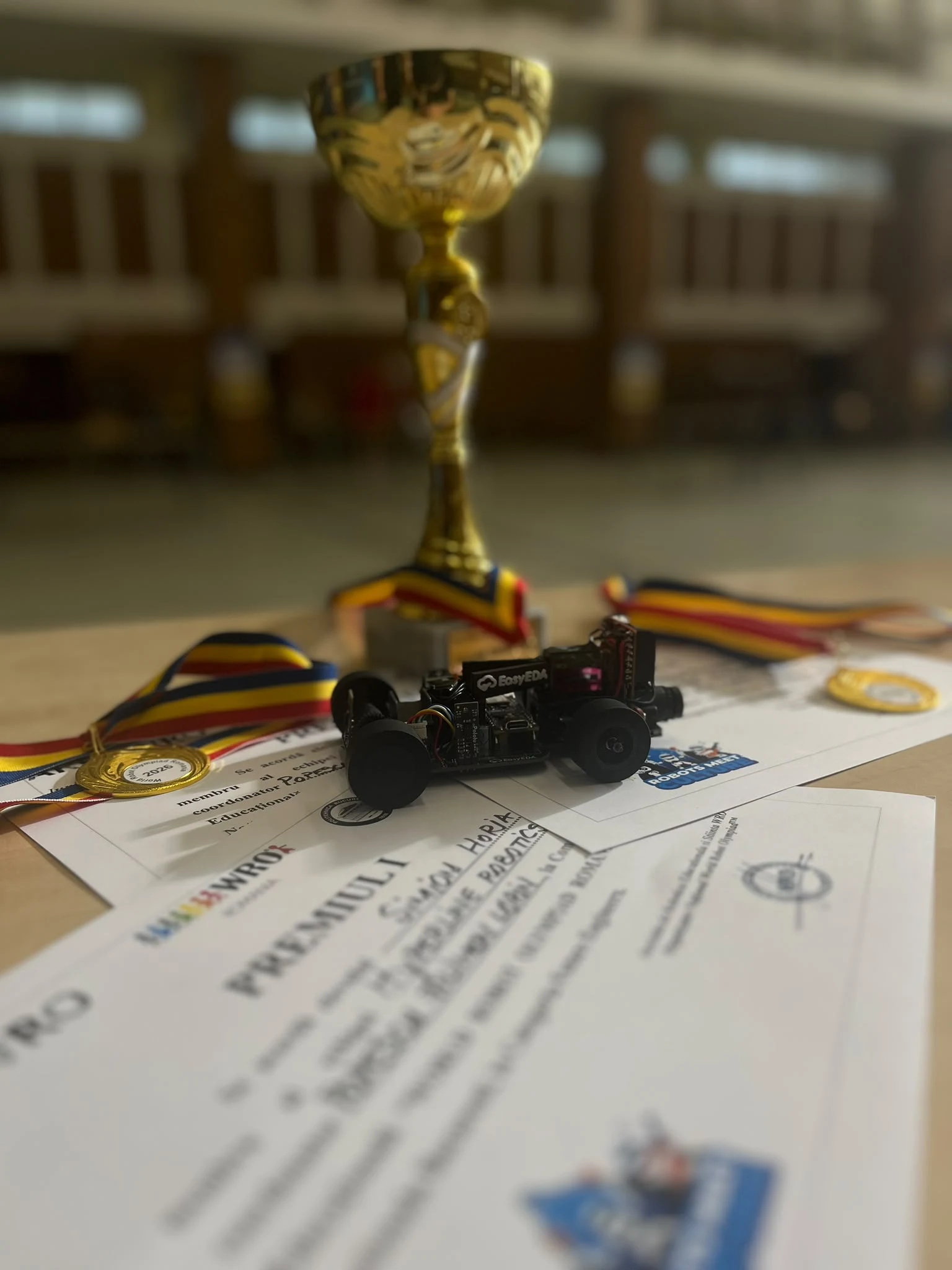 WRO National 2026 robot displayed with the winning trophy, medals and certificate